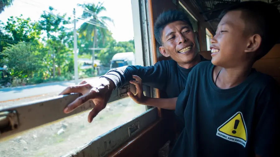 Des enfants rient à la fenêtre d’un train
